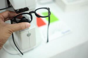 Hand holding eyeglasses in optical store photo