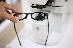 Hand holding eyeglasses in optical store photo