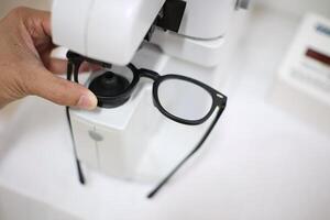 Hand holding eyeglasses in optical store photo