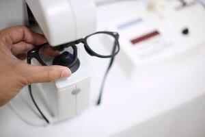 Hand holding eyeglasses in optical store photo