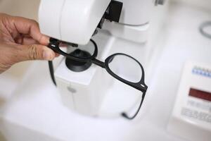 Hand holding eyeglasses in optical store photo