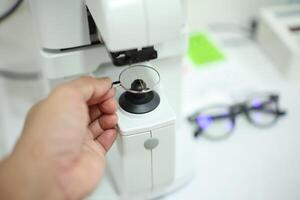 Hand holding eyeglasses in optical store photo