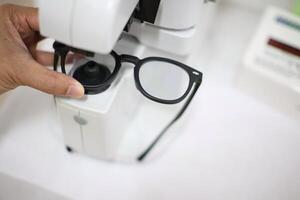 Hand holding eyeglasses in optical store photo