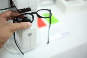 Hand holding eyeglasses in optical store photo