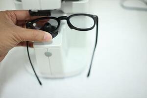 Hand holding eyeglasses in optical store photo