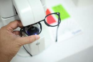Hand holding eyeglasses in optical store photo