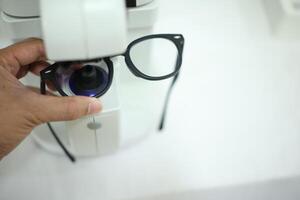 Hand holding eyeglasses in optical store photo