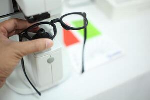 Hand holding eyeglasses in optical store photo