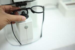 Hand holding eyeglasses in optical store photo