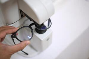 Hand holding eyeglasses in optical store photo