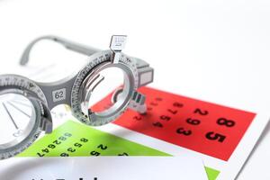 Trial frame glasses for eye test on chart in optical store photo