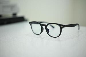 Hand holding eyeglasses in optical store photo