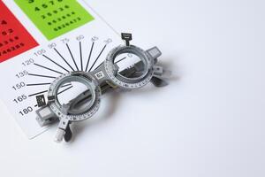 Trial frame glasses for eye test on chart in optical store photo