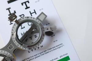 Trial frame glasses for eye test on chart in optical store photo