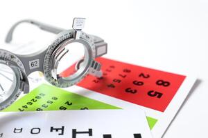 Trial frame glasses for eye test on chart in optical store photo