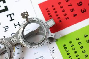 Trial frame glasses for eye test on chart in optical store photo