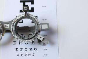 Trial frame glasses for eye test on chart in optical store photo