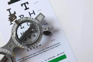Trial frame glasses for eye test on chart in optical store photo