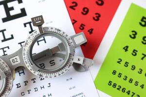 Trial frame glasses for eye test on chart in optical store photo