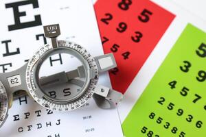 Trial frame glasses for eye test on chart in optical store photo