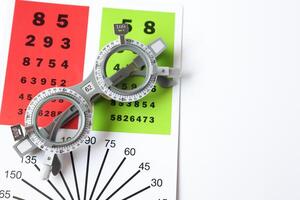 Trial frame glasses for eye test on chart in optical store photo