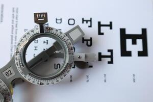 Trial frame glasses for eye test on chart in optical store photo