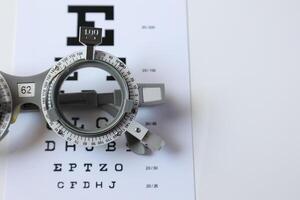 Trial frame glasses for eye test on chart in optical store photo