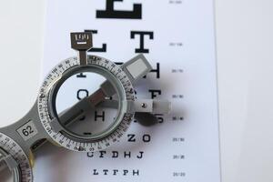 Trial frame glasses for eye test on chart in optical store photo