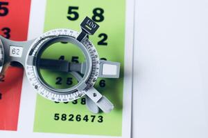 Trial frame glasses for eye test on chart in optical store photo