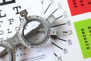 Trial frame glasses for eye test on chart in optical store photo