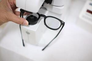 Hand holding eyeglasses in optical store photo
