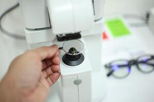 Hand holding eyeglasses in optical store photo