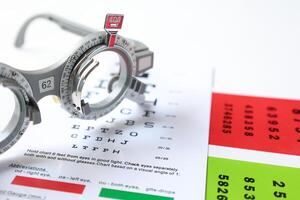 Trial frame glasses for eye test on chart in optical store photo