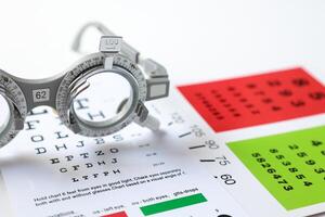 Trial frame glasses for eye test on chart in optical store photo