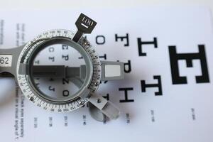Trial frame glasses for eye test on chart in optical store photo