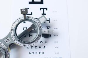 Trial frame glasses for eye test on chart in optical store photo