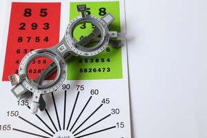 Trial frame glasses for eye test on chart in optical store photo