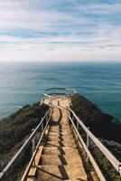 Stairs above the ocean with a blue sky on the background photo