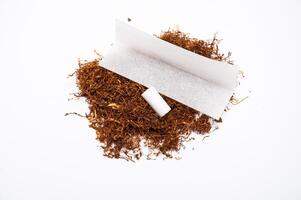 Hand rolling tobacco and filters and paper on the white background photo