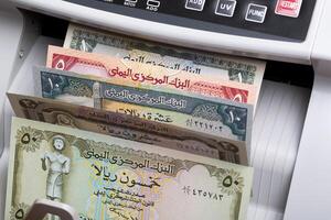 Old Yemeni rial in a counting machine photo