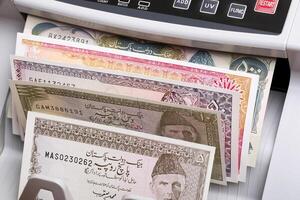Old Pakistani rupee in a counting machine photo
