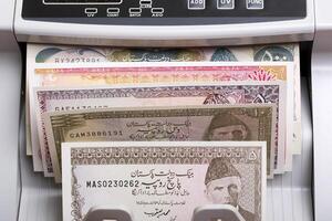 Old Pakistani rupee in a counting machine photo