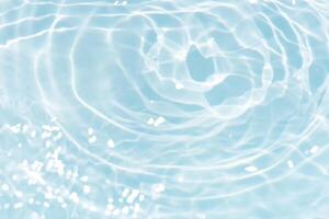 Bluewater waves on the surface ripples blurred. Defocus blurred transparent blue colored clear calm water surface texture with splash and bubbles. Water waves with shining pattern texture background. photo