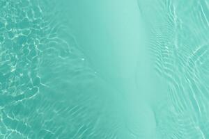 Blue water with ripples on the surface. Defocus blurred transparent blue colored clear calm water surface texture with splashes and bubbles. Water waves with shining pattern texture background. photo