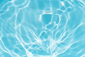 Bluewater waves on the surface ripples blurred. Defocus blurred transparent blue colored clear calm water surface texture with splash and bubbles. Water waves with shining pattern texture background. photo