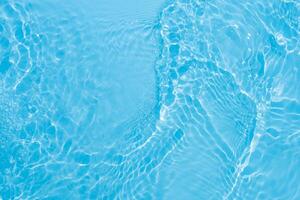 Blue water with ripples on the surface. Defocus blurred transparent blue colored clear calm water surface texture with splashes and bubbles. Water waves with shining pattern texture background. photo