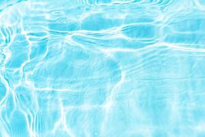 Bluewater waves on the surface ripples blurred. Defocus blurred transparent blue colored clear calm water surface texture with splash and bubbles. Water waves with shining pattern texture background. photo