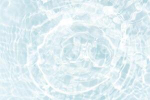 Blue water with ripples on the surface. Defocus blurred transparent blue colored clear calm water surface texture with splashes and bubbles. Water waves with shining pattern texture background. photo