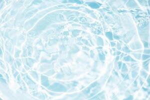 Blue water with ripples on the surface. Defocus blurred transparent blue colored clear calm water surface texture with splashes and bubbles. Water waves with shining pattern texture background. photo