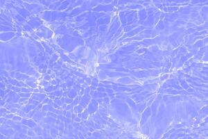 Blue water with ripples on the surface. Defocus blurred transparent blue colored clear calm water surface texture with splashes and bubbles. Water waves with shining pattern texture background. photo